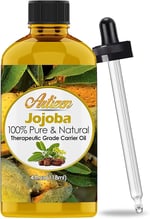 a bottle of jojoba oil with a glass bottle of jojoba oil