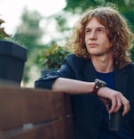 a man sitting on a bench in a park