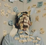 Gestresster Mann hat zu viele Aufgaben auf Post It Zetteln.