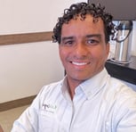a man in a white shirt and a coffee maker