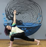 Rachel yoga pose in front of blue water mural