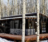 Modern prefab modular tiny home in a snowy forest setting