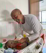 a man is feeding a baby in a high chair