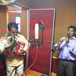 Manohar Brass Band in a music recording studio, recording their latest music.