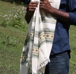 a man  standing in the grass with Vasanth shawl