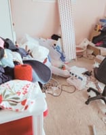 Cluttered craft room filled with boxes, crafting supplies, and disorganised items.
