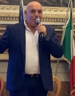 a man in a suit and tie is holding a microphone