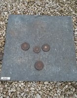 a stone slab with coins and coins on it