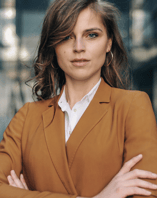a woman in a brown jacket and white shirt