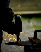 a man is grinding a piece of metal with sparks