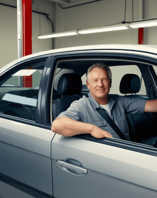 Happy man with his car, enjoying reliable service and comfort after visiting AMI Service & Rental