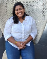 Picture of Elizabeth Jolly sitting in a wicker chair with a white shirt