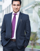 a man in a suit and tie is standing in front of a building