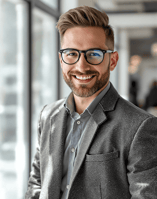 a man in a suit and glasses smiling