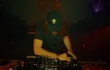 a man in a hat and a hat on a dj booth
