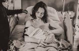 Mama cradling her newborn baby in a hospital bed in Grand Rapids, MN.