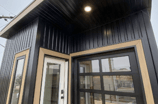 Modern prefab modular tiny home with black metal exterior