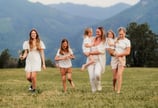 Familie läuft lachend auf einer Wiese
