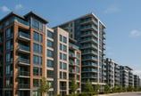 a row of apartment buildings with a street light in the foreground, condominiums in montreal