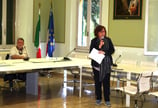 a woman standing in front of a table with a microphone