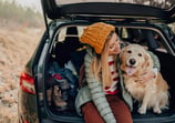 mujer sentada en coche con su perro