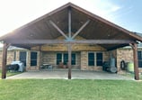 Larged covered patio with a vaulted wooden ceiling.