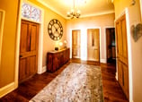 The Hallway at Gourock Seaview Holiday Let with a view with side table and large clock on the wall