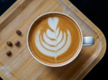 a cup of coffee with a leaf design on the side