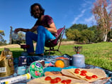 a man sitting in a chair with food on a blanket