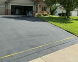 a driveway with fresh sealcoat blacktopping
