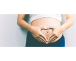Coeur avec les mains sur le ventre d'une femme enceinte