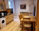 a kitchen at The kitchen at Gourock Seaview Holiday Let with a washing machine and dinner table