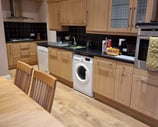 The kitchen at Gourock Seaview Holiday Let with a dining table and washing machine