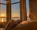 The bed at Gourock Seaview Holiday Let with a view of the sun setting over the water