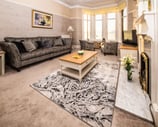 The spacious living room at Gourock Seaview Holiday Let with a couch, armchairs and a fireplace