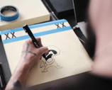 a man is drawing a cartoon character on a notebook