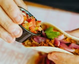 Taco con carne desmechada y pico de gallo en Santa Lola