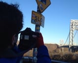 photographer filmaker camera shooting bicycle sign New York City George Washington Bridge