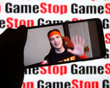a person holding a cell phone in front of a wall with a sign that says