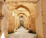 a narrow passageway with arches and arches in the middle of a stone wall