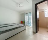 Comfortable double bed in a hotel room with a window overlooking the city