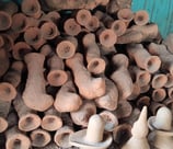 "A pile of wax-moulded brass sculptures covered with special clay, ready for casting in traditional Dhokra art from Bastar"