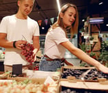 Casal de Homem e Mulher fazendo compras de frutas em um mercado