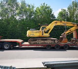 yellow digger loaded on the back of a van in dudley