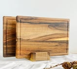 a wooden cutting board with a pine cone on top