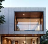 render de fachada de casa moderna de lujo con volúmenes de concreto, madera y ventanales panorámicos en barranquilla