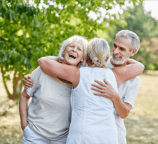 A group of older adult friends hugging