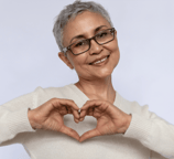 Middle aged woman making a heart with her hands.