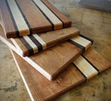 a pile of wood cutting board boards with a knife and knife