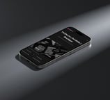 An iPhone displaying the YVZN website on its screen.